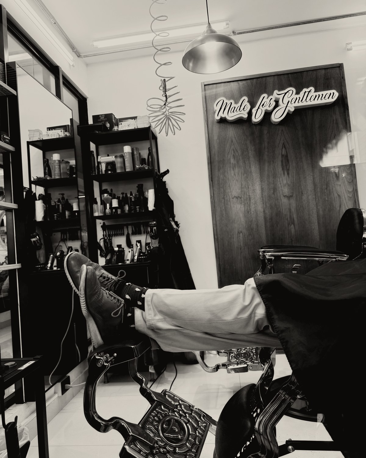Mr. Moustache Barbershop — un cliente descansando en el sillón, bajo el letrero Made for Gentlemen