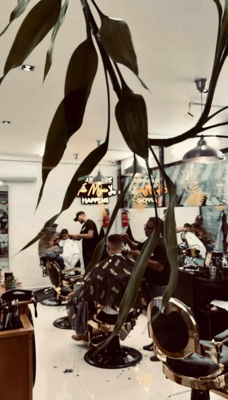 Mr. Moustache Barbershop — el salón en un día de trabajo, visto entre las plantas